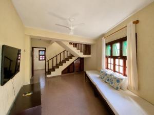 a living room with a couch and a staircase at Hotel Canto do Rio Maresias in Maresias