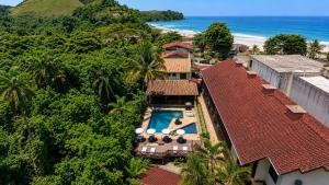 an aerial view of a resort with a swimming pool and the ocean at Hotel Canto do Rio Maresias in Maresias