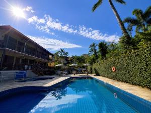 a swimming pool in front of a building with a resort at Hotel Canto do Rio Maresias in Maresias