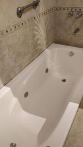 a white bath tub in a bathroom with a shower at Apart hotel Agua Dorada in Cavalango +6 photos