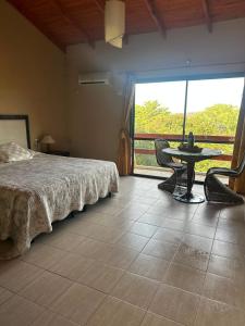 a bedroom with a bed and a table and a window at Apart hotel Agua Dorada in Cavalango