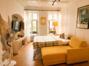 a bedroom with a bed and a couch and a tv at 120m2 l Golden Castle Loft l Old Town l Thun in Thun +33 photos