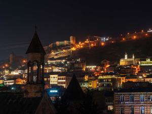 a city lit up at night with a clock tower at ibis Styles Old Tbilisi in Tbilisi City