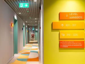 a hallway of a hospital with a yellow and green wall at ibis Styles Old Tbilisi in Tbilisi City
