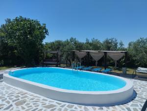 a swimming pool in a yard with chairs around it at ΑΡΧΟΝΤΙΚΟ ΣΤΟΥΣ ΠΡΟΠΟΔΕΣ ΤΟΥ ΟΡΟΥΣ ΔΙΡΦΥΣ in Loútsa