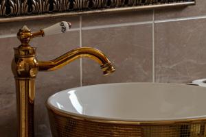 a sink in a bathroom with a gold faucet at Lux Stays in Prishtinë