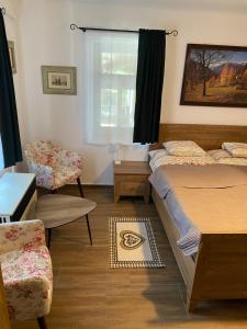 a bedroom with two beds and a chair and a window at Patakparti Pihenő in Cserépfalu