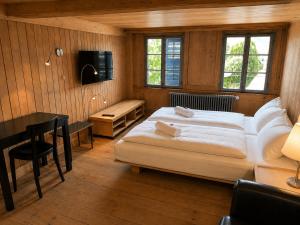 a bedroom with a bed and a table and a desk at Klösterli Malters in Malters