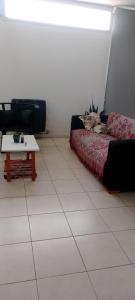 a cat laying on a bed in a room with a table at Departamento luminoso y amplio in San Antonio de Areco