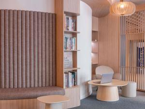 a room with a book shelf with a laptop on a table at Novotel Marseille Centre Gare in Marseille