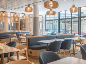 a restaurant with tables and chairs and windows at Novotel Marseille Centre Gare in Marseille