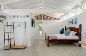 a bedroom with a bed in a white room at Kai Cottage in Bergvliet
