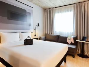 a hotel room with a large bed and a couch at ibis Madrid Norte Las Tablas in Madrid