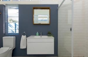 a bathroom with a white sink and a mirror at Kai Cottage in Bergvliet