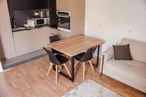 a small kitchen with a wooden table and chairs at Lux Stays in Prishtinë +10 photos