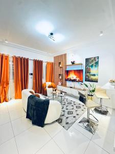 a living room with orange curtains and a fireplace at Dyden luxury appartement in Douala