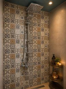 a bathroom with a shower with a tile wall at Riad Hamad Tijani in Fez