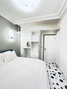 a white bedroom with a white bed and a white door at Dyden luxury appartement in Douala