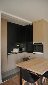 a kitchen with a wooden table and black cabinets at Lux Stays in Prishtinë