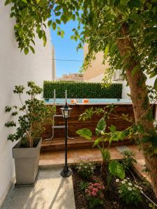 a bench in a garden with plants and a candle at Oasis Pool Flat-near 2 metro stations- in Piraeus