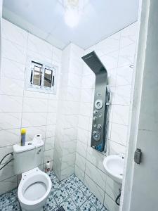 a white bathroom with a toilet and a sink at Dyden luxury appartement in Douala