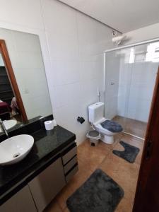 a bathroom with a toilet and a sink and a mirror at Pousada Conecta Travel in Rifaina +11 photos