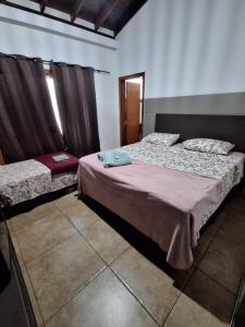 a bedroom with two beds in a room at Pousada Conecta Travel in Rifaina