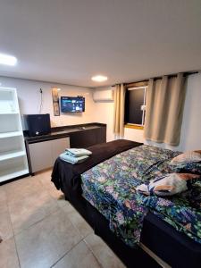 a bedroom with a bed and a flat screen tv at Pousada Conecta Travel in Rifaina