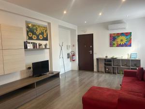 a living room with a red couch and a television at Casa Alessandra in Cassibile