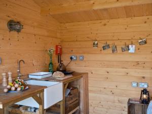 a kitchen in a log cabin with a sink at The Hoppers Hut in Weald