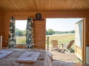 a bedroom with a bed and a view of a field at The Hoppers Hut in Weald +9 photos