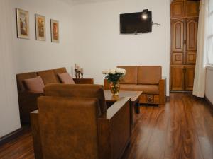 ein Wohnzimmer mit zwei Sofas und einem Fernseher in der Unterkunft Hotel Boutique Inca Real in Cuenca