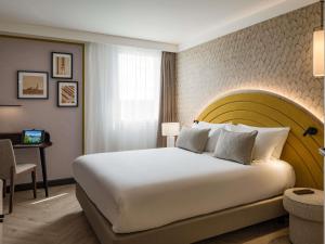 a hotel room with a large bed and a desk at Mercure Chartres Est in Chartres +106 photos