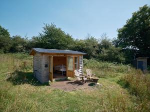 a small shed in the middle of a field at The Hoppers Hut in Weald