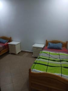 a bedroom with two beds and two night stands at Ridha in Djerba