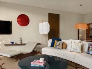 a living room with a white couch and a table at SLS The Red Sea in Ḩanak