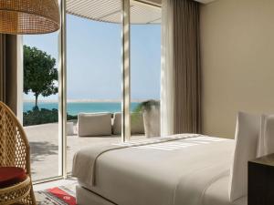 a bedroom with a bed and a view of the ocean at SLS The Red Sea in Ḩanak +134 photos