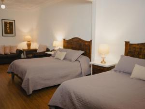 ein Hotelzimmer mit zwei Betten und einem Wohnzimmer in der Unterkunft Hotel Boutique Inca Real in Cuenca