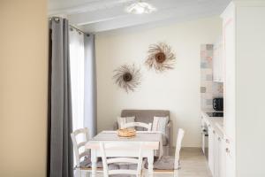 a white dining room with a table and chairs at Su Mari in Villasimius