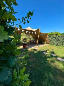 ein Zelt mit Tisch und Stühlen in einem Hof in der Unterkunft Vakantiewoning Bisonder in Bilzen