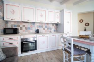 a kitchen with white cabinets and a counter top at Su Mari in Villasimius