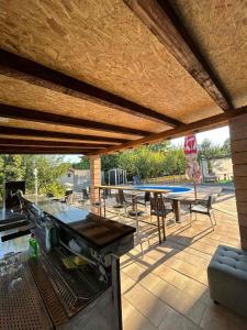a patio with a grill and a table and chairs at VILLA M Rustic & Spa in Slatina Varoš