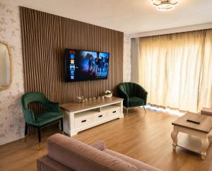 a living room with a couch and a tv on a wall at Reza Almere in Almere