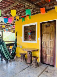 a room with a table and chairs and a yellow wall at Hotel Fazenda Oásis in Carpina