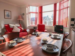 a living room with a wooden table and chairs at Sylvian in Bexhill