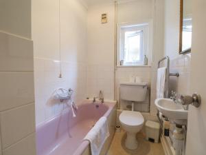 a bathroom with a tub and a toilet and a sink at Sylvian in Bexhill +11 photos