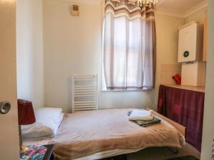 a small room with a bed and a window at Sylvian in Bexhill