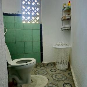 a bathroom with a toilet and a trash can at Palm Paradise in Diani Beach +22 photos