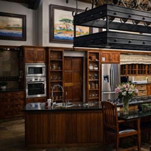 a kitchen with wooden cabinets and a kitchen island with a refrigerator at Sable Mountain in Hekpoort