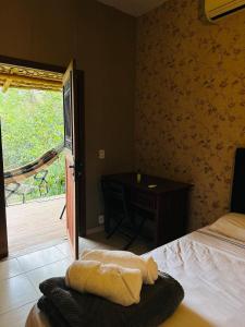 a bedroom with a bed and a desk and a window at Varanda do Vale in Palmas